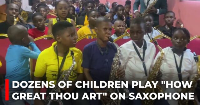 Dozens of children play How Great Thou Art on saxophone